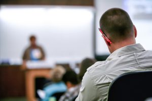 A student listens to someone speaking in a lecture hall